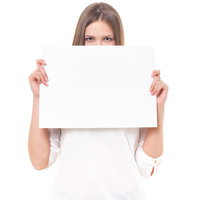 白い紙を両手で持って顔の下半分を隠す茶色い髪の外国人女性の写真