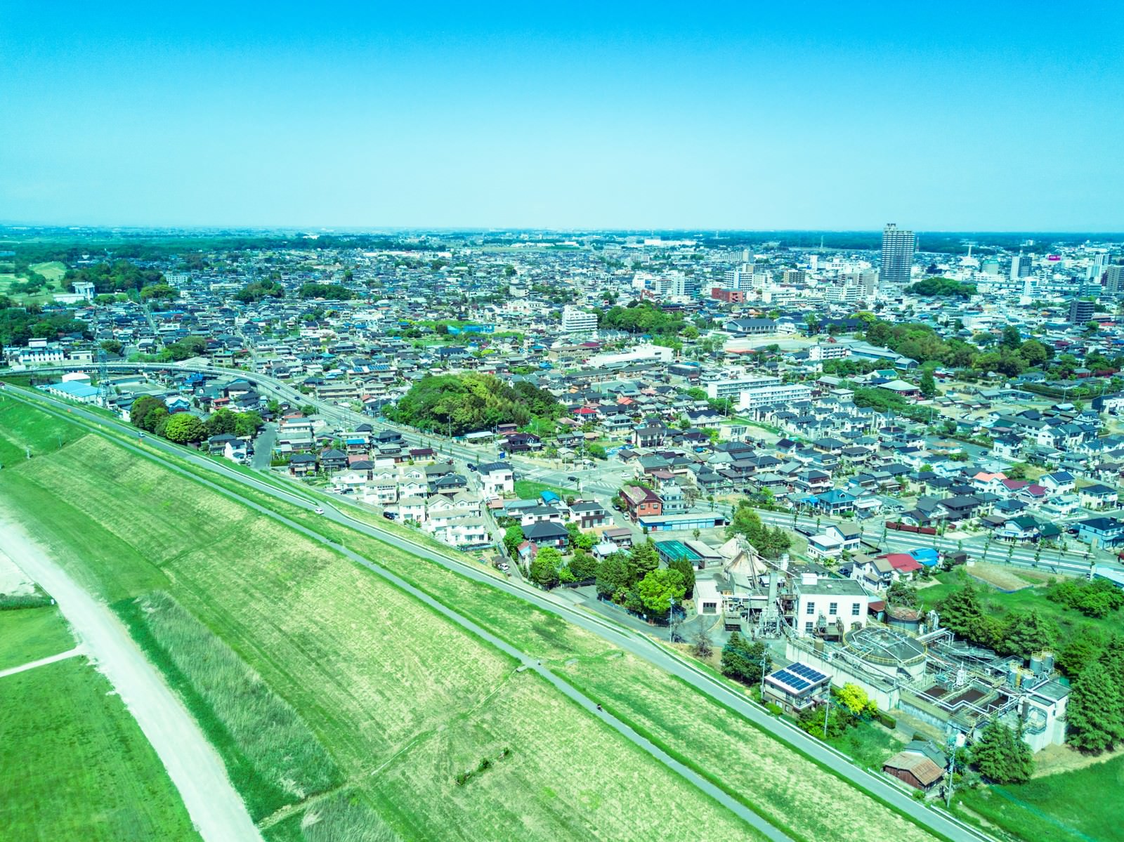 リバーフィールド古河の河川敷と住宅街を空撮した風景