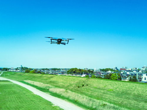 河川敷の上空を飛行するマルチコプター（ドローン）