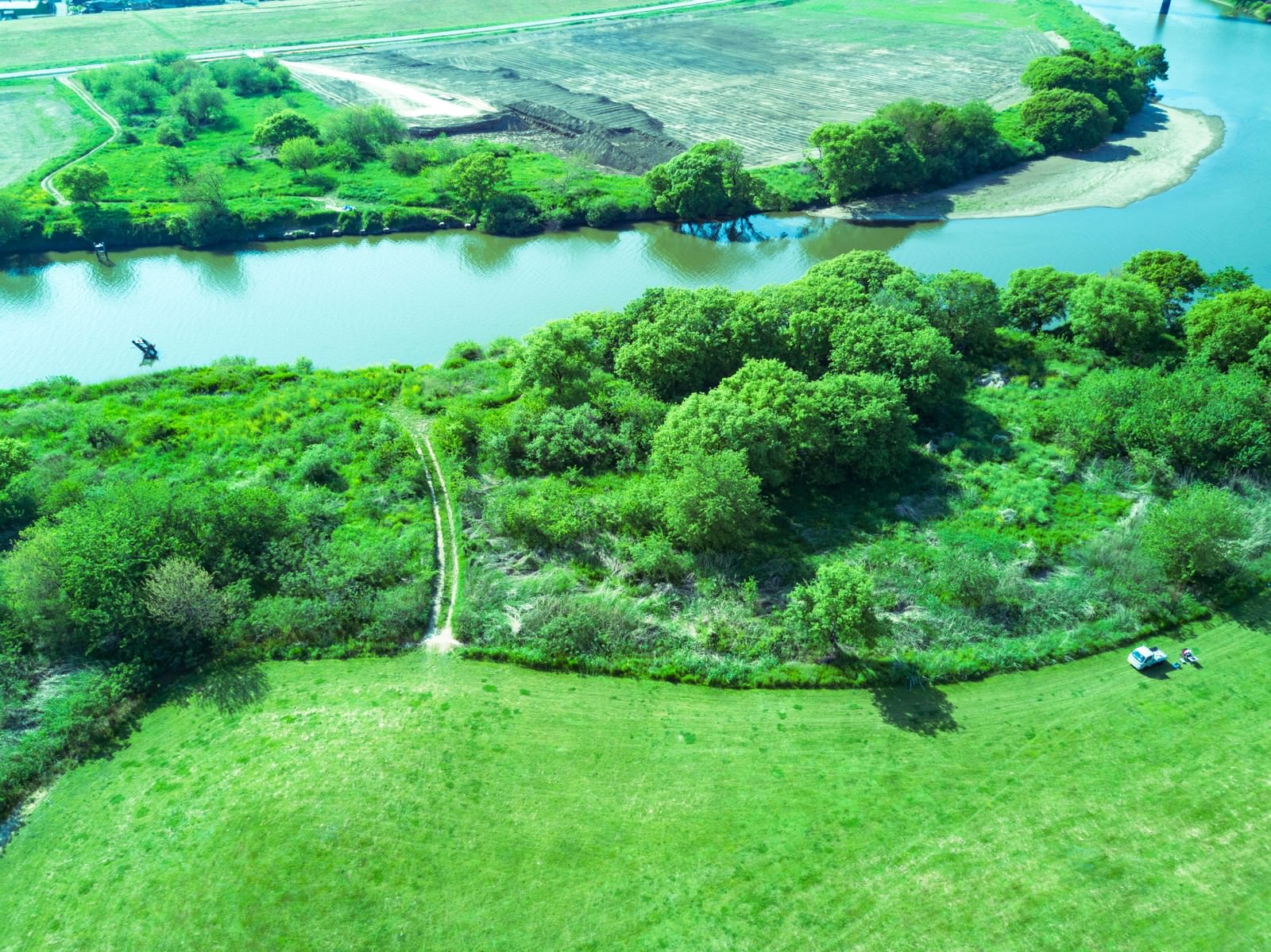 渡良瀬川沿いの緑の広場を空撮した風景