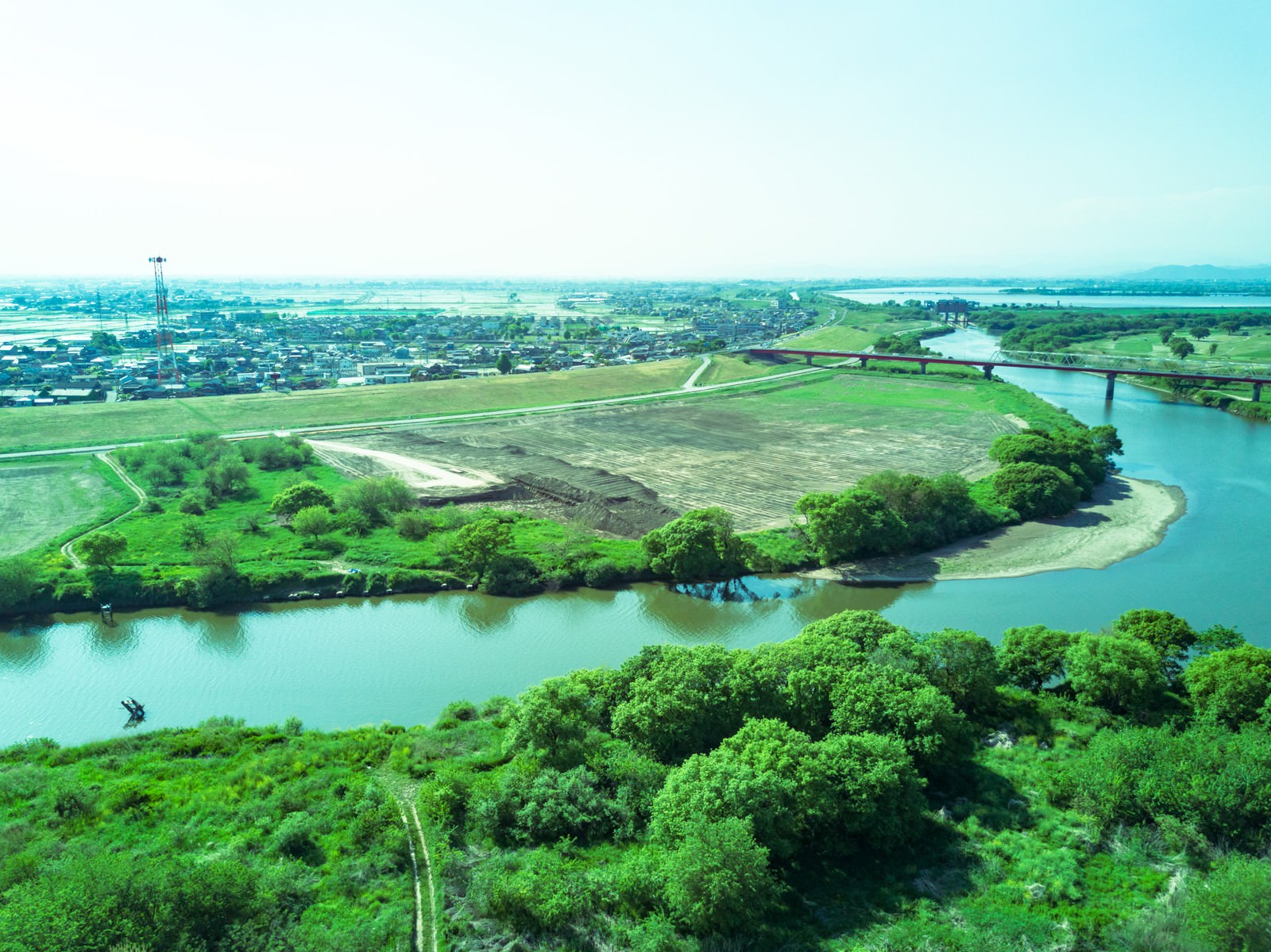 上空から撮影した渡良瀬川の下流域、蛇行する川と緑の田園風景