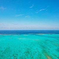 池間大橋近くの透明度高い宮古ブルーの海を空撮で撮影の写真