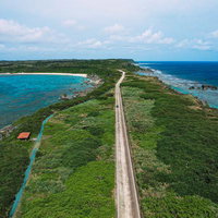 平安名埼灯台までの一本道を走る車（空撮）の写真