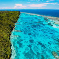 断崖絶壁の伊良部島三角点を囲む宮古ブルーの海（空撮）の写真