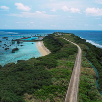 平安名埼灯台まで続く道と岩礁が広がる宮古島の海（空撮）の写真