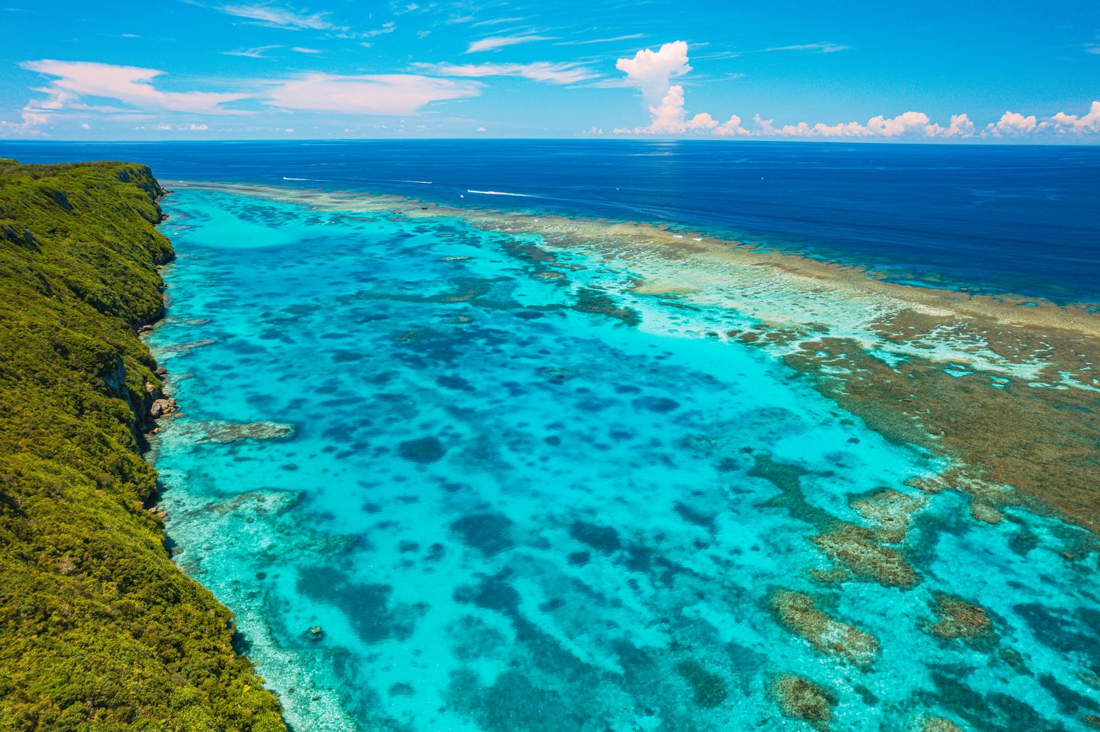 伊良部島の崖から見下ろす宮古ブルーのサンゴ礁と深い海