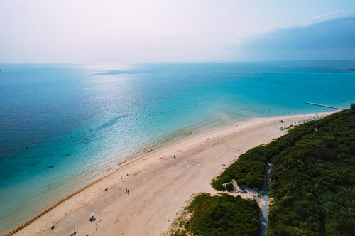 宮古ブルーに輝く前浜ビーチの海岸線と海水浴客