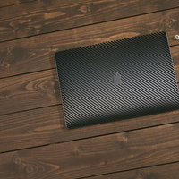 木目テーブルに並ぶMacBookとiPhoneとAirPodsの写真