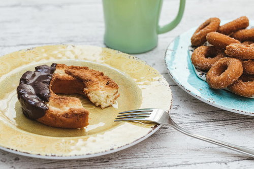 白い皿に置かれた食べかけのチョコレートドーナッツ