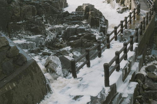 日本海の荒波と波の花が覆う遊歩道