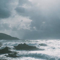 自然の力強さを感じる荒れた日本海と海岸線の写真