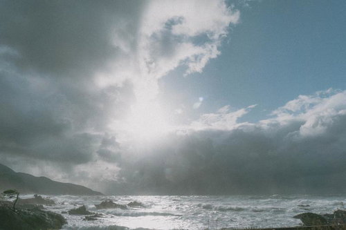 雲の切れ間から届く光に照らされる冬の日本海