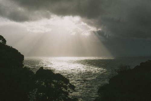 雲間から降り注ぐ光のカーテンで煌めく日本海