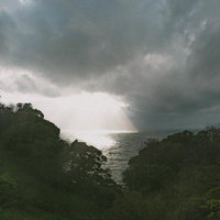 雲間から差し込む光が輝く冬の日本海の写真