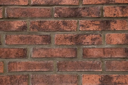 茶色いレンガの壁のテクスチャー、経年変化で汚れたモルタル目地