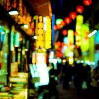 夜の下町路地裏に灯る居酒屋の看板と昭和レトロな町並みの写真