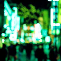 夜間の歓楽街を行き交う人々とネオン看板の夜景の写真