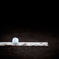 野球のピッチャープレートに置かれた硬球の写真
