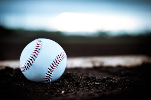 グラウンドの土に転がる硬球、野球の試合風景