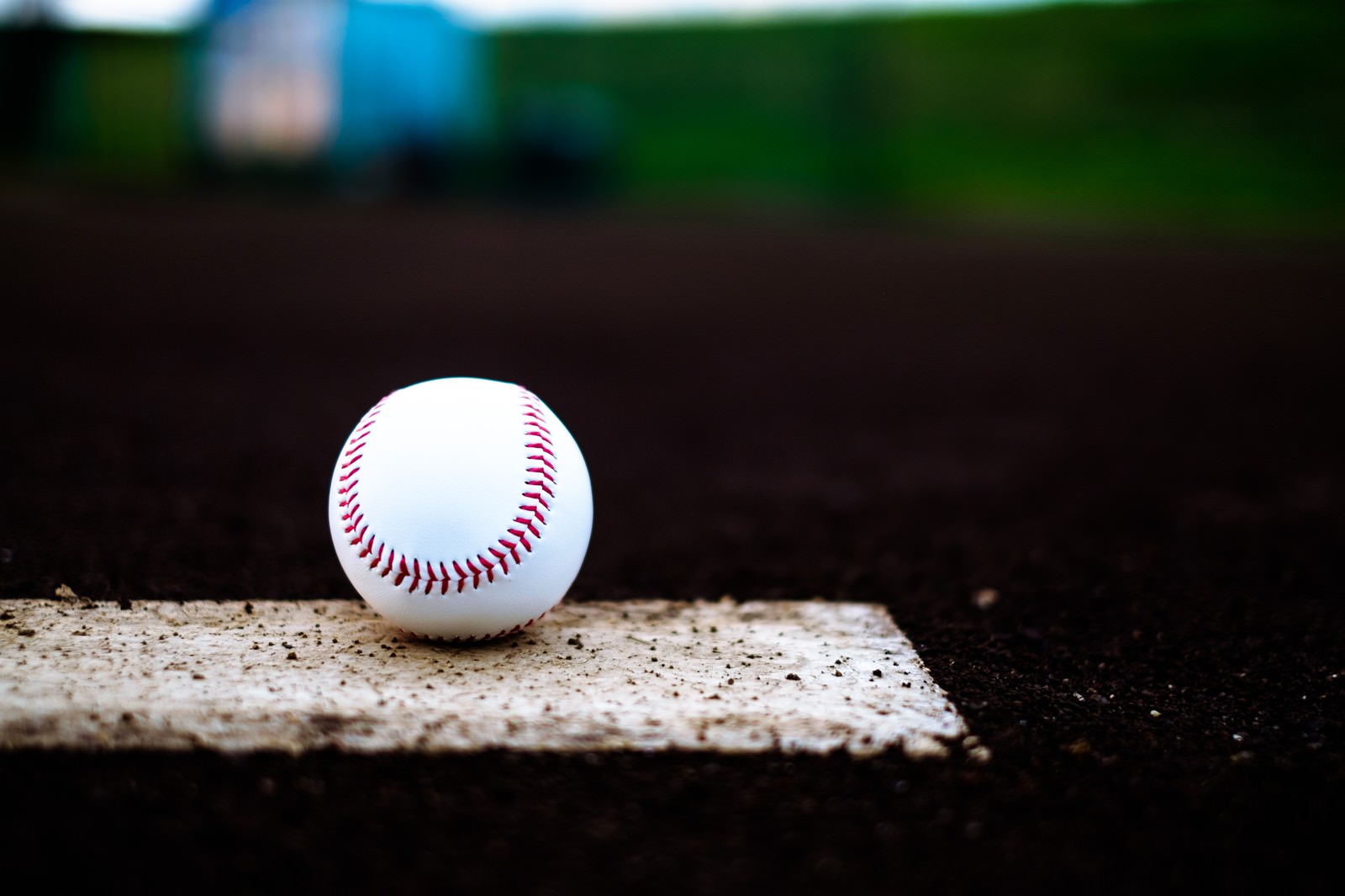 ベースの上に置かれた赤い縫い目の野球ボール