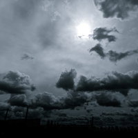 怪しい雲行きの空に光差す積雲と太陽、モノクロで捉えた天候の変化の写真