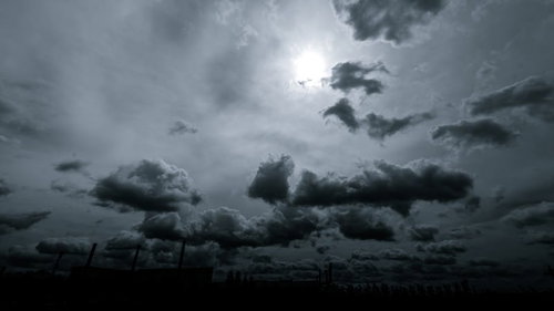怪しい雲行きの空に光差す積雲と太陽、モノクロで捉えた天候の変化