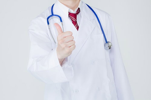 親指を立てて「グッジョブ！」のポーズをする笑顔の白衣の医師