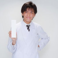 白い札を正面に向けて持つ白衣の医師のメッセージポーズの写真