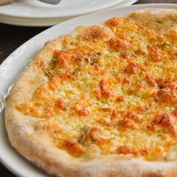 ピザとピザカッターのチーズピザの写真