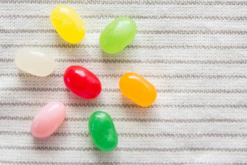 白い布の上に並ぶカラフルなゼリービーンズ7個