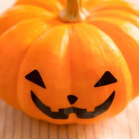 ハロウィンのかぼちゃお化け、木製テーブルに飾られたジャックオーランタンの写真