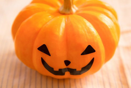 ハロウィンのかぼちゃお化け、木製テーブルに飾られたジャックオーランタン