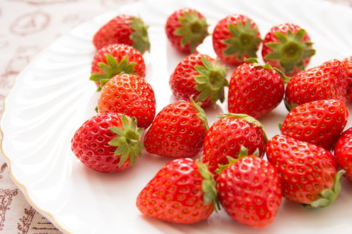 白いお皿に並べた約15個のイチゴ