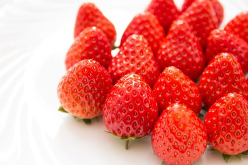 白い面に並んだ新鮮な赤いイチゴ