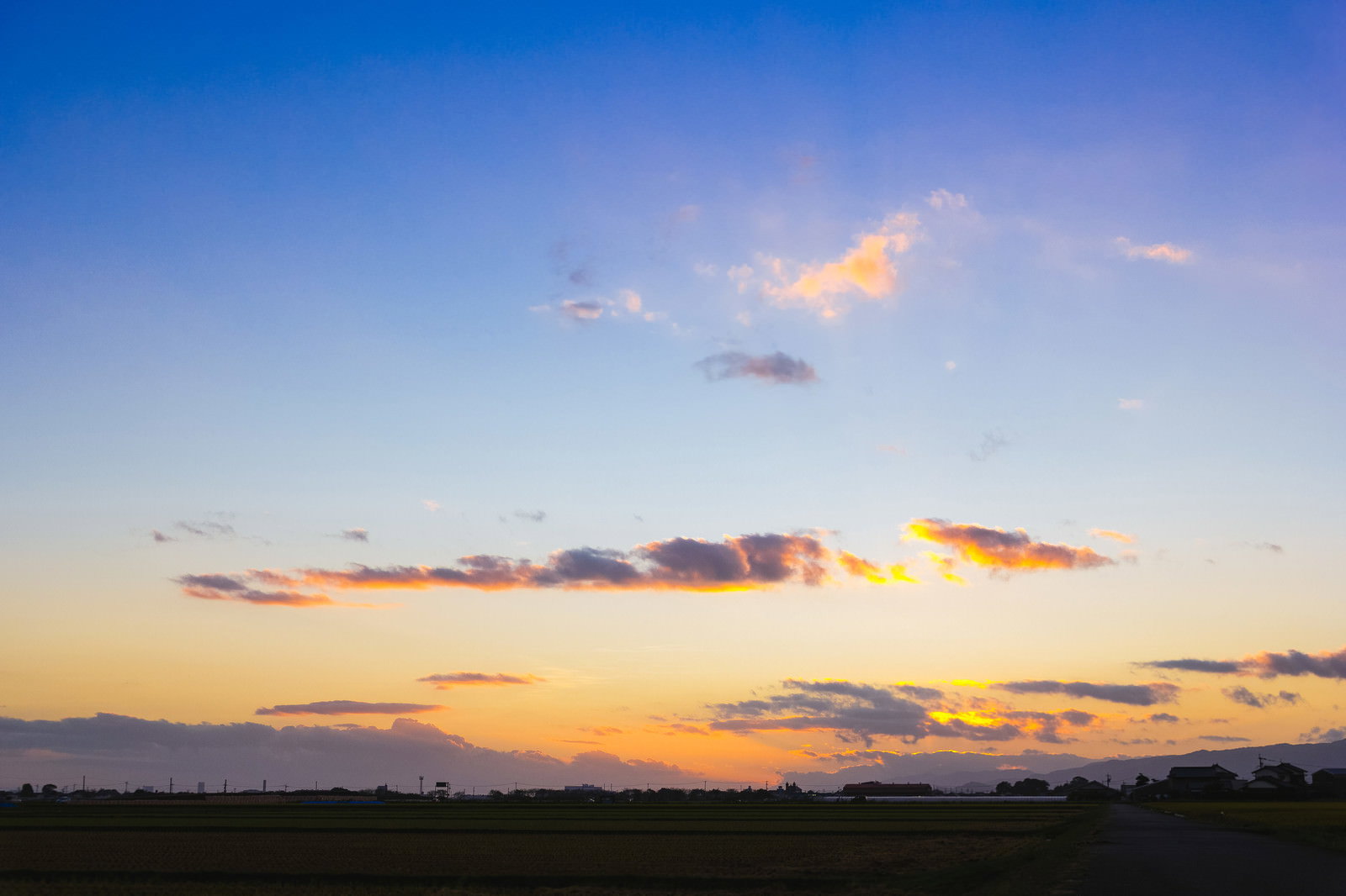 オレンジ色の夕焼け空の下に広がる大刀洗の田んぼと畑の風景