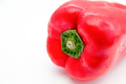 緑のヘタが付いた赤いパプリカ、白背景での撮影