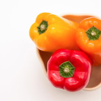 赤・オレンジ・黄色のパプリカ三種の野菜食材の写真