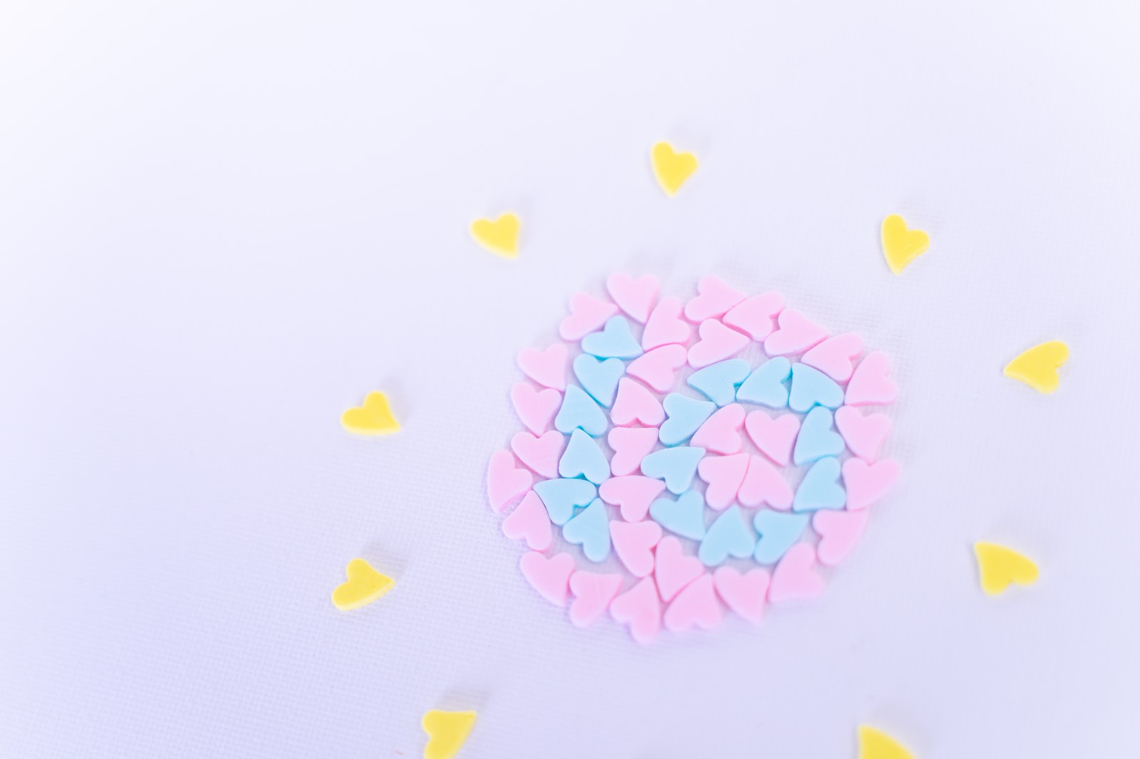淡い紫の背景に黄色い星が散らばり、ピンクのハート形のお菓子で作られた数字の10