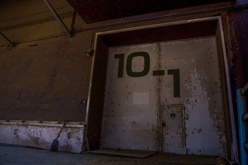 錆びた扉と番号が付いた貸し倉庫、廃墟の古い倉庫施設の写真