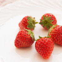 白い丸皿に円を描くように並んだいちごの写真