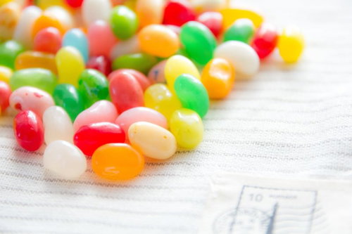 白い布の上に散らばるカラフルなゼリービーンズ