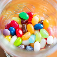 透明ボトルに詰まったカラフルなジェリービーンズの写真