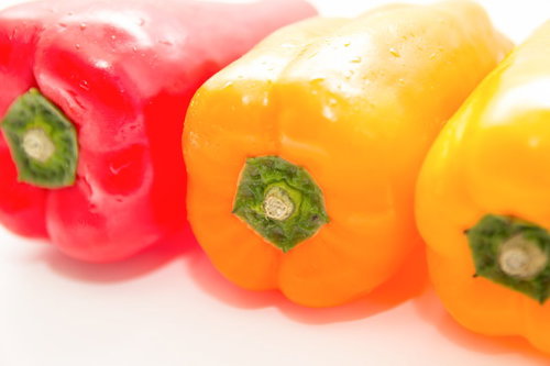 白背景に水滴がついた赤と黄色のパプリカ3個