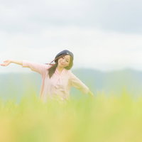 金色に実った稲穂ともんぺ姿の女性が立つ福岡の田園風景の写真
