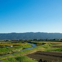 青空と遠景の山々が見える福岡県大刀洗の農地平野の写真