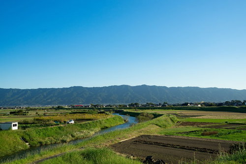 青空と遠景の山々が見える福岡県大刀洗の農地平野