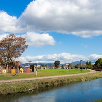 川沿いにある大刀洗公園の遊具広場と青空、春の景観の写真