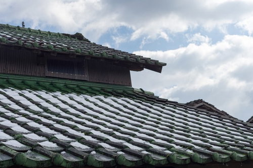 瓦屋根に雪が残る日本家屋の冬景色