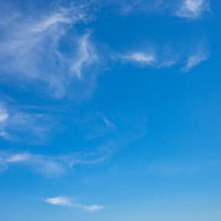 青空に浮かぶちぎれた白い雲と晴天の日中風景の写真