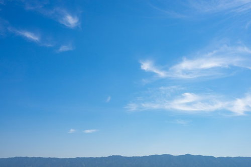 晴れた日に見える青空と白い雲、遠くの山並み